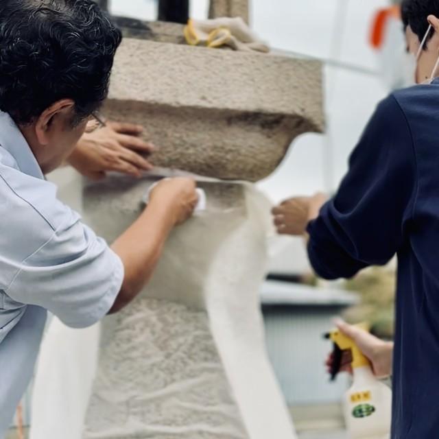 拓本を採取するために和紙を水で張り付ける作業